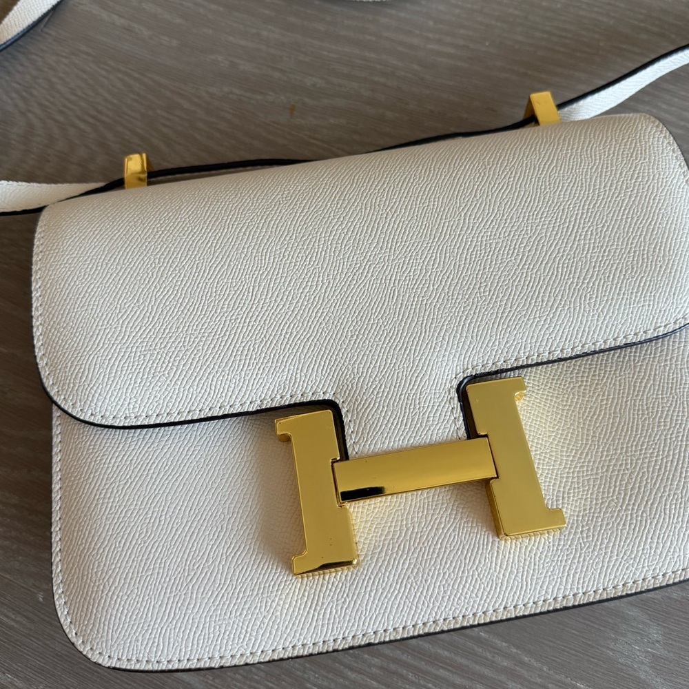 Cream color H Constance crossbody bag with gold hardware.